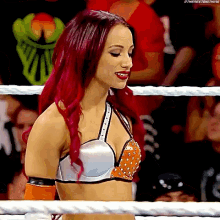 a woman with red hair is in a wrestling ring
