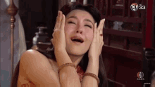 a woman is covering her face with her hands while laughing .