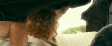 a woman with red hair is sitting in the back seat of a car .
