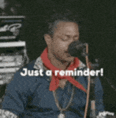 a man singing into a microphone with the words just a reminder written below him