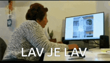 a woman sits at a desk in front of a computer and the words lav je lav are visible