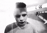 a black and white photo of a man with his mouth open and a robot in the background .