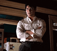 a man in a white shirt and black pants with his arms crossed
