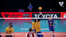 a volleyball game is being played in front of toyota ads