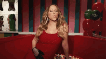 a woman in a red dress blowing a kiss while holding a bucket of candy .