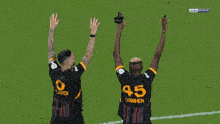 two soccer players are celebrating a goal in front of a crowd with bein sports written on the screen