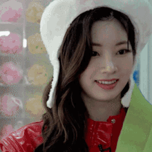 a woman wearing a white hat and a red jacket smiles for the camera