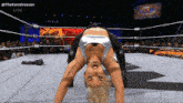 a woman is doing a handstand in a wrestling ring with a new texas sign in the background