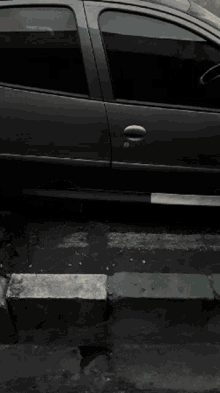 a black car is parked on the side of a street