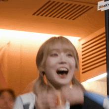 a woman with pigtails is smiling in front of a sign that says the k