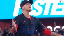 a man in a toronto baseball uniform is standing in front of a large screen