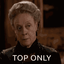 a close up of an elderly woman 's face with the words `` top only '' written on it .
