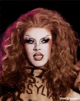 a close up of a drag queen 's face with a shirt that says asylum