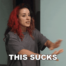 a woman with red hair says " this sucks " with her arms outstretched