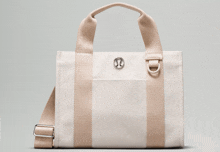a white tote bag with a pink strap and a lululemon logo on the front