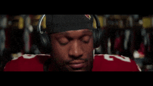 a football player wearing headphones and a headband with a cardinals logo on it