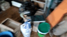a green bucket sits in a pile of boxes