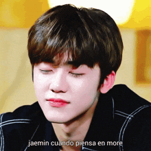 a close up of a person 's face with the words jaemin cuando piensa en more written below it