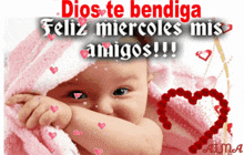 a baby is wrapped in a pink blanket and the words dios te bendiga feliz miercoles mis amigos