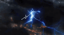 a lightning bolt is flying through a dark cloudy sky at night .