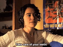 a woman says " take care of your teeth " in front of a poster that says stay out only