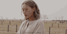 a woman wearing earrings and a necklace is standing in a field with the words leesiyoen tumblr written on the bottom