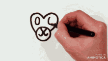 a person is drawing a dog with a black marker on a piece of paper .