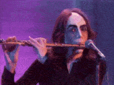 a man is playing a flute in front of a microphone