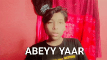 a young man is wearing a black shirt that says abeyy yaar on it