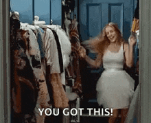 a woman in a white dress is dancing in a closet with the words `` you got this '' written above her .