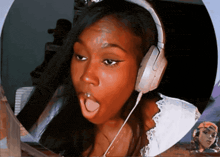 a woman wearing headphones has her mouth open