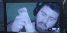 a man with a beard and headphones is on a video call on a laptop