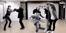 a group of men are dancing together in a room .