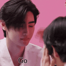 a close up of a man 's face with the word go written on it .