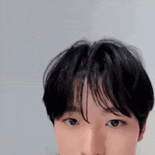a close up of a young man 's face with black hair