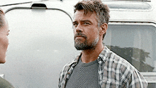 a man in a plaid shirt stands next to a woman in a green shirt
