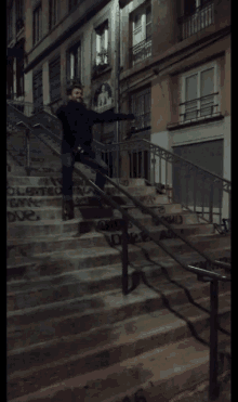 a man is sitting on a set of stairs with graffiti on them that says ' a '