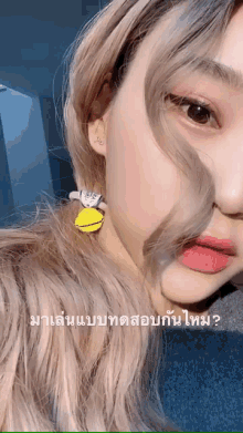 a close up of a woman 's face with a yellow earring on