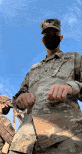 a man in a us army uniform is wearing a black face mask
