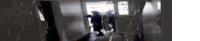 a group of people are walking down a hallway in a building .