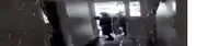 a group of people are walking down a hallway in a building .