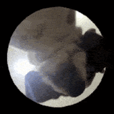 a close up of a person 's face in a circle with a black background
