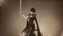 a black and white photo of a person holding a sword