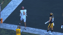 a football player wearing a jersey with the number 9 on it stands on the field
