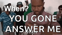 a man is standing in front of a crowd and says " when ? you gone answer me "