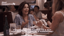 two women are sitting at a table with a sign that says real housewives