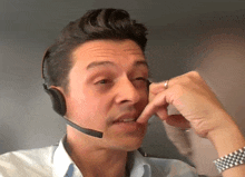 a man wearing a headset and a watch is talking on a cell phone