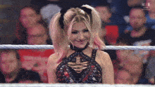 a woman in a wrestling ring with the word win on the bottom left