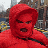 a person wearing a red ski mask and a red jacket with the word ice on the front