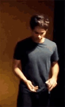 a young man in a black shirt is standing in a dark room
